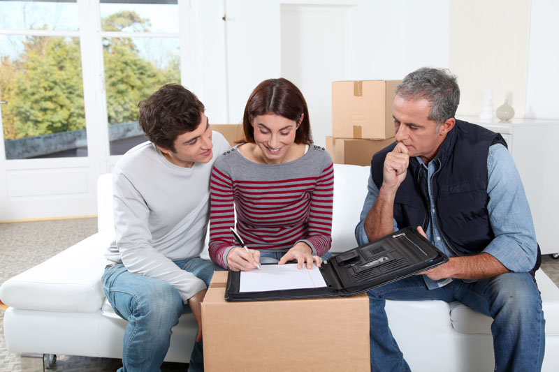 Young couple signing contract for home moving Young couple signing contract for home moving